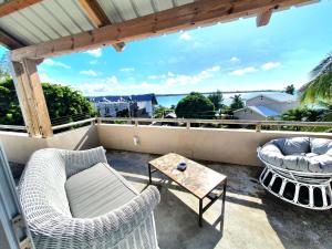 balcón con sillas, mesa y vistas al océano en Cozy pavillon with private jacuzzi on rooftop terrace - Jolly's Rock en Grand Gaube