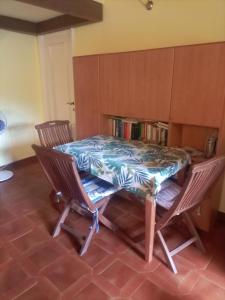 a table and chairs in a room with a book shelf at Soledad in Bonassola