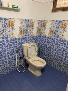 baño con aseo en una habitación con azulejos azules en Surf Villa Hiriketiya en Matara