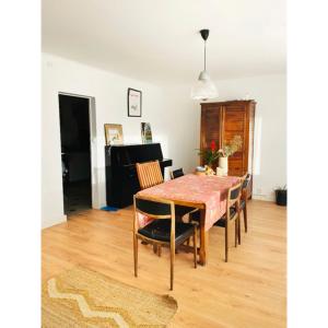 ein Esszimmer mit einem Tisch mit Stühlen und einem Klavier in der Unterkunft Cosy house in Guingamp ! in Guingamp