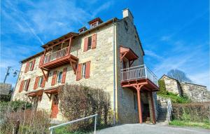 un edificio antiguo con un balcón en el lateral. en 4 Bedroom Stunning Home In Castelnau D Mandailles, en Castelnau-de-Mandailles