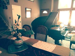 uma sala de estar com uma mesa e um piano em Golden Gate Getaway em Fircrest