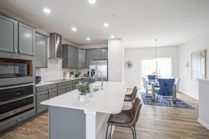 a kitchen with a white counter and chairs in it at DreamPlace Bana Home in Indianapolis