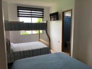 um quarto com 2 camas e uma janela em Pangora, habitación privada de Flor de Lis Beach House em Playas