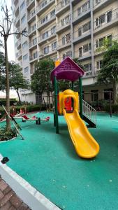 un parque infantil con un tobogán frente a un edificio en South Residences, en Manila