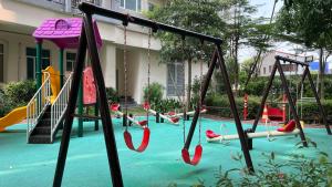 een lege speeltuin met glijbanen en schommels bij South Residences in Manilla