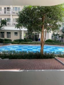 een blauw zwembad met een boom voor een gebouw bij South Residences in Manilla
