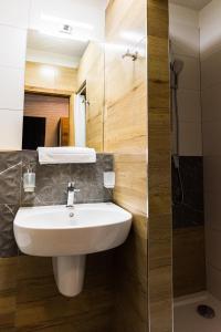 uma casa de banho com um lavatório e um chuveiro em Hotel Carrera em Rimavská Sobota