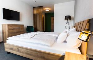 リマフスカー・ソボタにあるHotel Carreraのベッドルーム1室(白いベッド1台、壁掛けテレビ付)