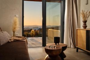 - un salon avec un canapé et une grande fenêtre en verre dans l'établissement Opuntia Suites, à Naxos Chora
