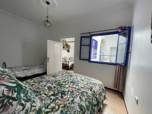 een slaapkamer met een bed en een raam bij Dar Azam in Essaouira