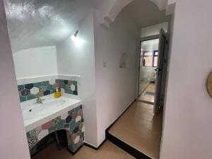 een badkamer met een wastafel en een douche bij Dar Azam in Essaouira