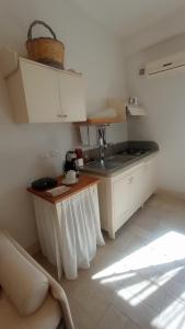 eine Küche mit einem Tisch und einem Waschbecken in einem Zimmer in der Unterkunft Tenuta alla Castellana in Gallipoli