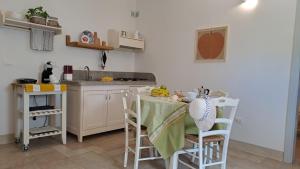 a kitchen with a table and chairs and a kitchen with a sink at Tenuta alla Castellana in Gallipoli