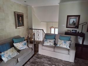 sala de estar con 2 sofás y almohadas azules en Villa Carmen en András