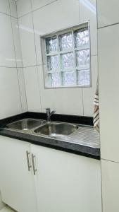a kitchen with a sink and a window at La Lucia Sleepover in Durban