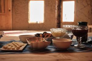 a table with bowls and wine glasses and bread at Altyn Oimok Yurt Camp in Tong