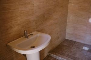 baño con lavabo blanco y paredes de madera en Altyn Oimok Yurt Camp, en Tong