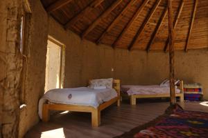 Tong的住宿－Altyn Oimok Yurt Camp，配有木天花板的客房内的两张床