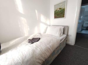 Una cama con sombrero en un dormitorio en Home In Harrow/Wembley en Harrow on the Hill