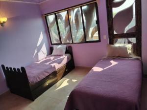 2 Betten in einem Zimmer mit 2 Fenstern in der Unterkunft Gran México in Mexiko-Stadt