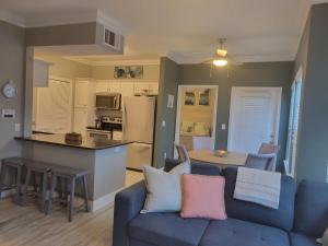 a living room with a blue couch and a kitchen at Peaceful Seaside Condo-Walking Path to the Beach in Corpus Christi