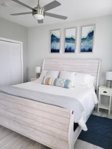 um quarto com uma grande cama branca e 2 janelas em Peaceful Seaside Condo-Walking Path to the Beach em Corpus Christi