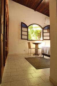 a dining room with a table and a window at Hospedaria Bem Te Vi Arraial d'Ajuda in Arraial d'Ajuda