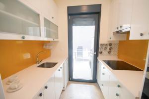 uma cozinha com armários brancos e uma porta com um lavatório em For Your Rentals Bonito Apartamento cerca Bernabeu MJU14B em Madri