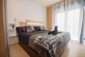 um quarto com uma cama com um bicho de peluche em For Your Rentals Bonito Apartamento cerca Bernabeu MJU14B em Madri