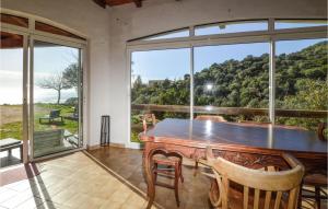 ein Esszimmer mit einem Tisch und einem großen Fenster in der Unterkunft 3 Bedroom Amazing Home In Casaglione in Casaglione