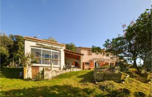ein Haus mit einem großen Fenster auf einem grünen Hof in der Unterkunft 3 Bedroom Amazing Home In Casaglione in Casaglione