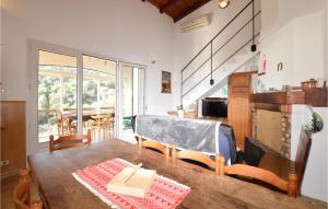 eine Küche und ein Esszimmer mit einem Holztisch und Stühlen in der Unterkunft 3 Bedroom Amazing Home In Casaglione in Casaglione