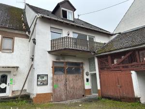 a house with a wooden door and a balcony at Weedenhof in Zornheim in Zornheim