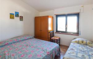 een slaapkamer met een bed, een kast en een raam bij 2 Bedroom Cozy Home In Roseto Capo Spulico in Roseto Capo Spulico