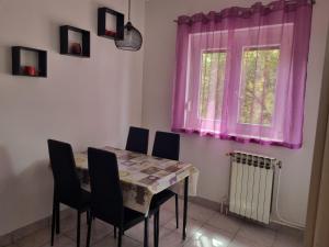 a dining room with a table and chairs and a window at Kristina in Vrbnik