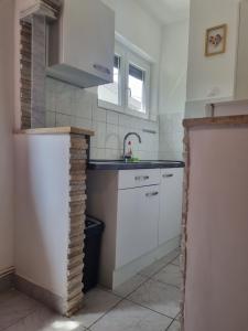 a kitchen with white cabinets and a sink at Kristina in Vrbnik
