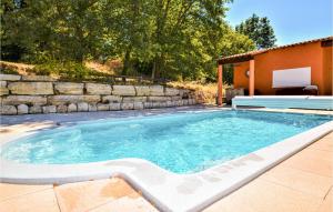 una piscina en un patio trasero con una pared de piedra en Lovely Home In St Just D Ardeche With Outdoor Swimming Pool, en Saint-Marcel-dʼArdèche