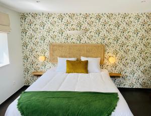 a bedroom with a large bed with a green blanket at La Bel échappée in Aubel