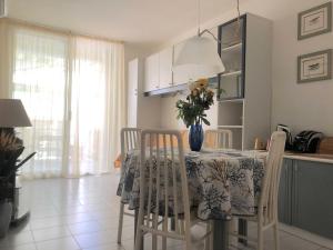 uma cozinha com uma mesa com um vaso de flores em Confortevole Bilocale Giardino Doppio Parcheggio em Punta Ala