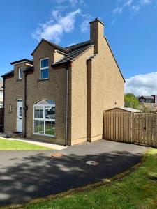 uma casa de tijolos com uma cerca em frente em Hopefield House, Portrush em Portrush