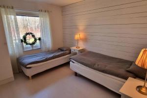 Un dormitorio con 2 camas y una ventana con una corona. en Trivsamt parhus i lugnt område inne i Tranås! en Tranås