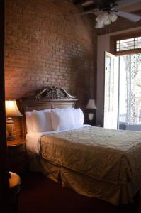 a bedroom with a bed with a brick wall at Jean Lafitte House in New Orleans