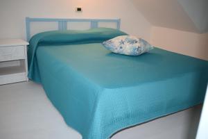 - un lit bleu avec un oreiller dans l'établissement Chicca marina, à Torre Canne