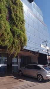 a car parked in front of a large building at Edifício Master in Cascavel