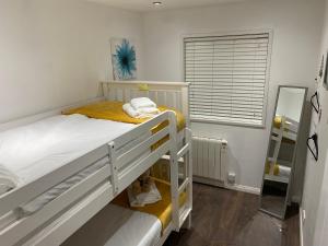 a bedroom with two bunk beds and a window at No12 Pats Place - Sleeps 6 - Sea views over Carbis Bay in Carbis Bay
