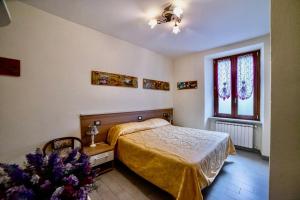 Schlafzimmer mit einem Bett und einem Fenster in der Unterkunft Residence Le stanze dei Visconti in Voltaggio
