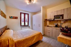 1 Schlafzimmer mit einem großen Bett und einer Küche in der Unterkunft Residence Le stanze dei Visconti in Voltaggio
