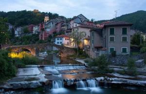 un puente sobre un río en una ciudad con una cascada en Residence Le stanze dei Visconti, en Voltaggio