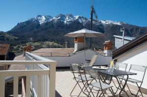 d'une terrasse avec une table et des chaises sur un balcon avec des montagnes. dans l'établissement TSS' - Ai Broli, Self Check-in, à Vigolo Vattaro